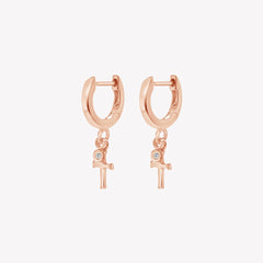 Rizen Jewelry rose gold vermeil Cross Huggie Hoop Earrings with white topaz stone dangle from the Calvary Collection.