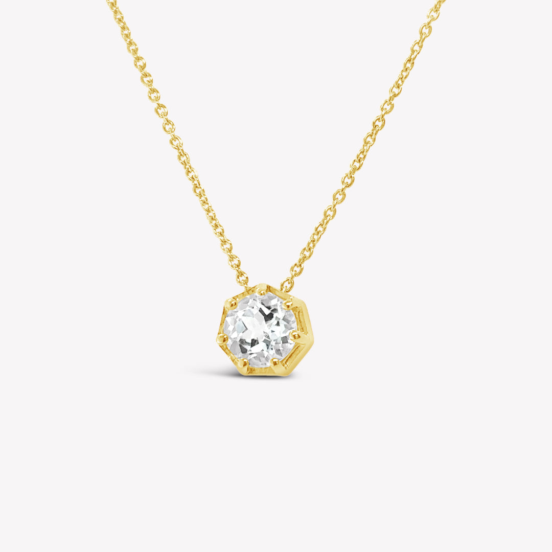 Rizen Jewelry Ebenezer solitaire white topaz necklace  in gold vermeil set in 7 prongs in a heptagon setting from the Chispa Collection. 