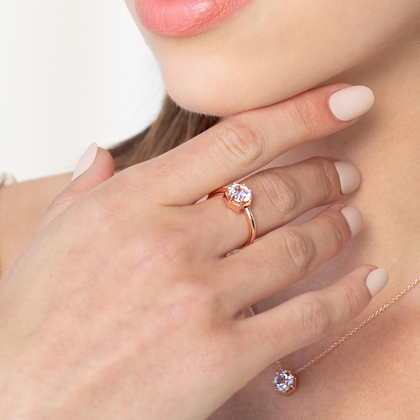 Close up of a christian woman wearing 18k rose gold white topaz Ebenezer Solitaire Ring from the Chispa Collection by Rizen Jewelry.