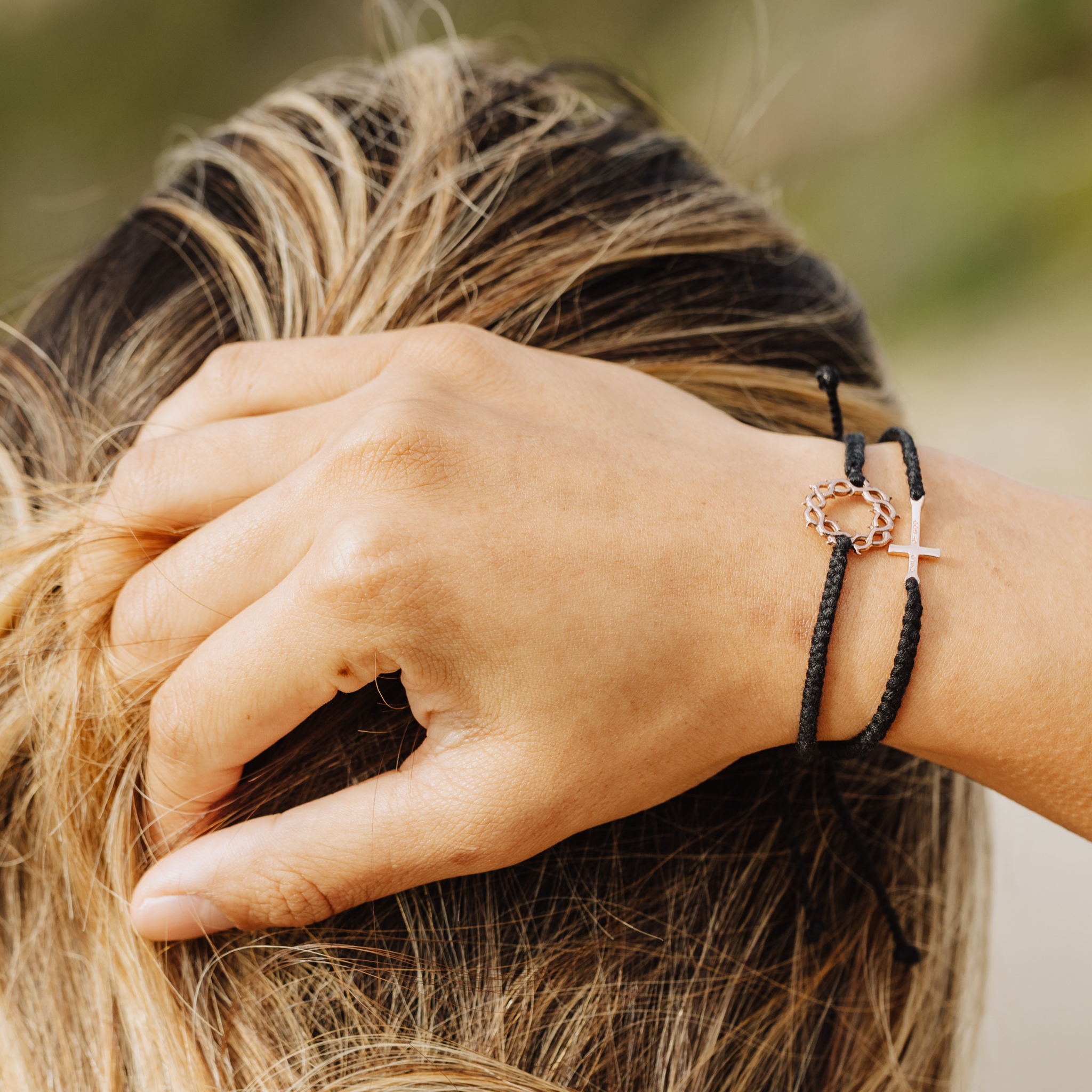 Rizen Jewelry Christian model wearing black crown of thorns rose gold  bracelet layered with Made4Ministry cross bracelet.