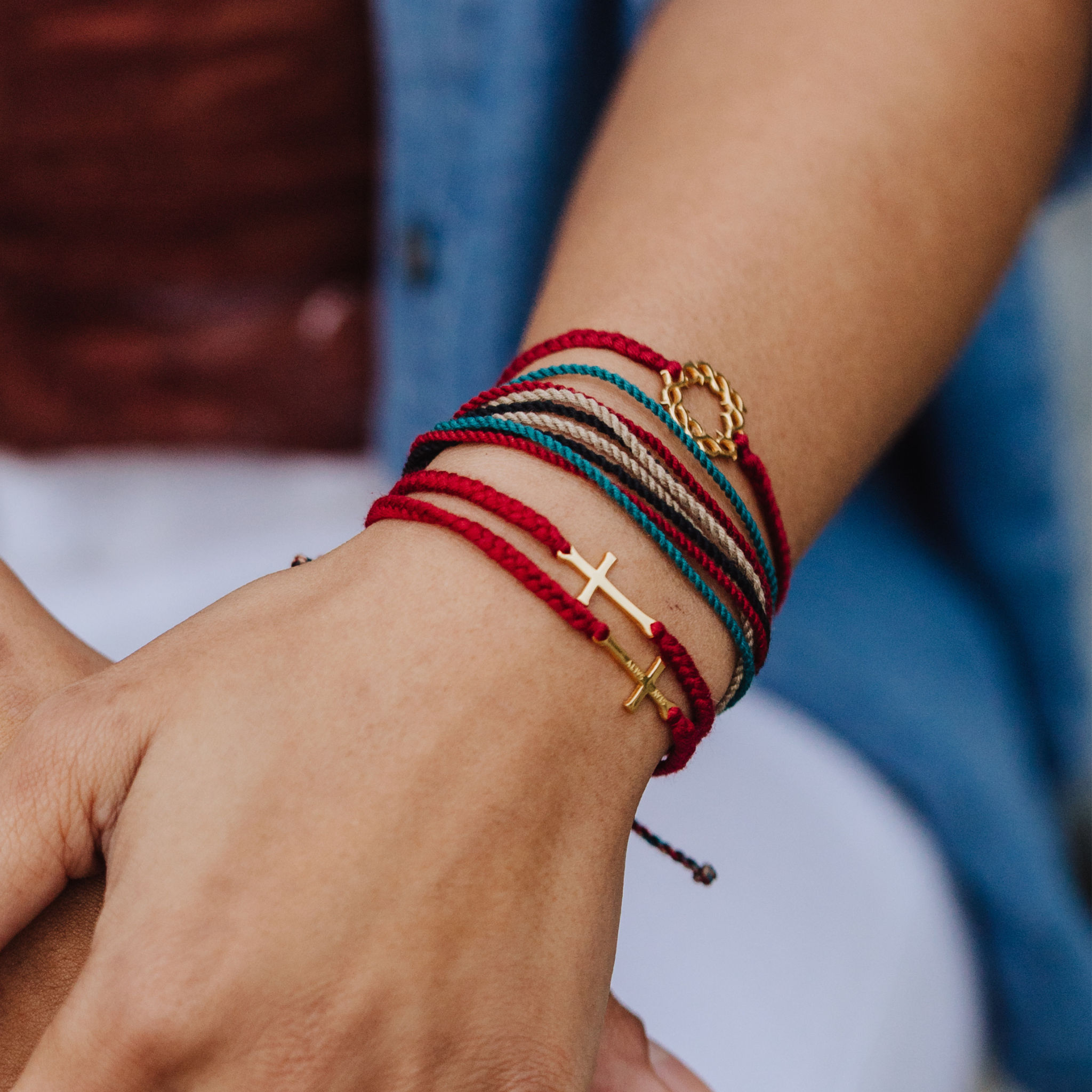 Rizen Jewelry Made4Ministry Faithful Be Magnified multicolor cord bracelet layered with Red Gold Cross and Crown of Thorns Bracelets. 