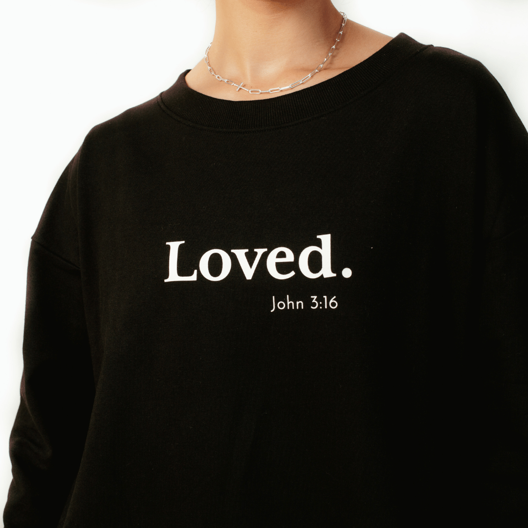 Close up of black " Loved. John 3:16" Peruvian cotton sweatshirt from the Be The Light Collection by Rizen Jewelry.