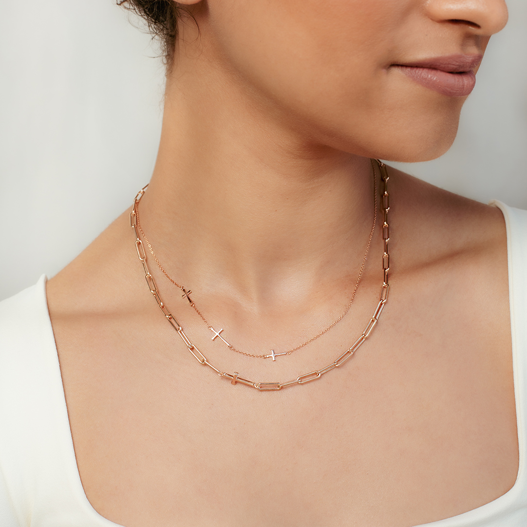 Christian woman wearing the chain breaker and calvary cross station necklaces in rose gold vermeil from the calvary collection by Rizen Jewelry