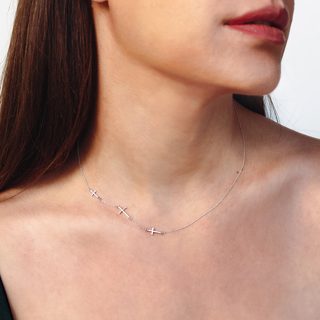 Close up of christian woman wearing the silver triple cross Calvary Necklace by Rizen Jewelry.
