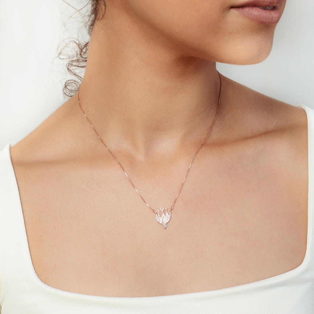 Christian woman wearing the Chispa de la Dove Necklace in rose gold vermeil from the Chispa Collection by Rizen Jewelry.
