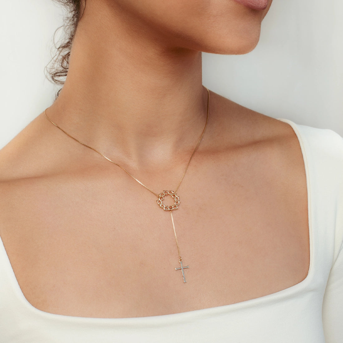 Christian woman wearing 18k gold vermeil Crown of Thorns Necklace with Cross Pendant from the Insignia Collection by Rizen Jewelry.