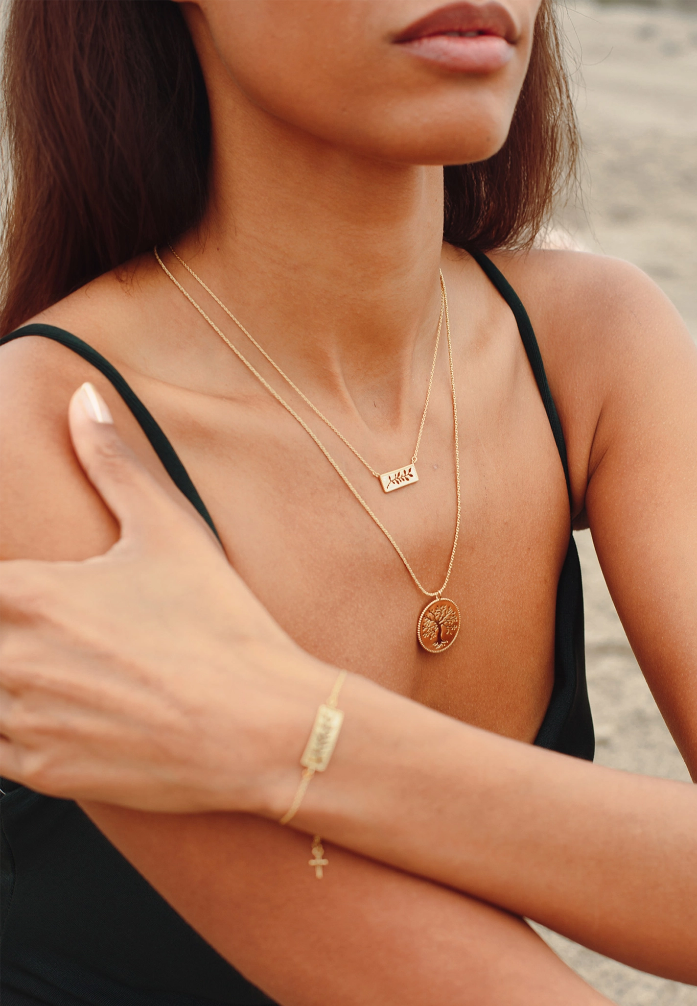 Christian woman wearing the gold Olive Tree and Olive Branch jewelry from the rooted Collection by Rizen Jewelry. 