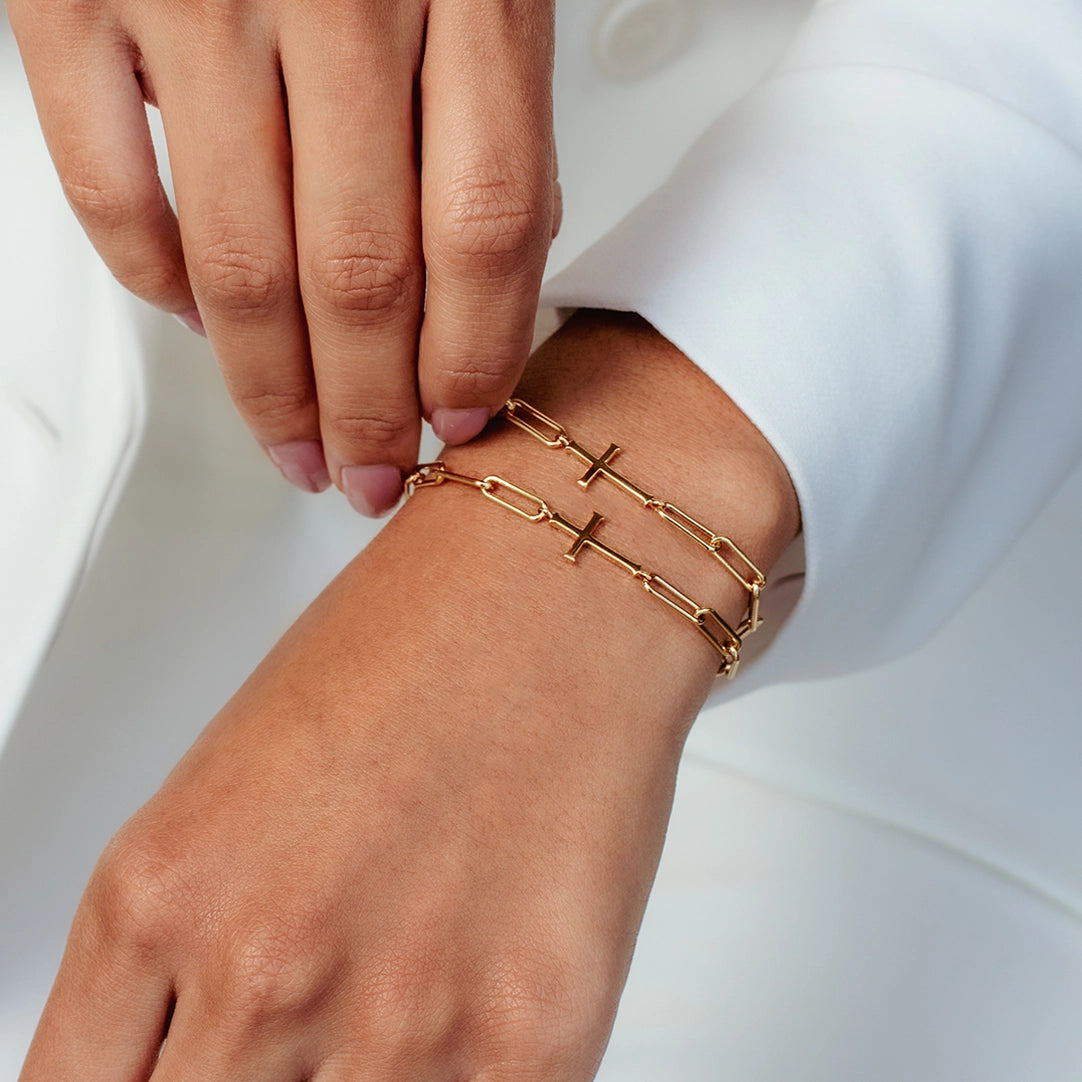close up of christian woman wearing two gold Chain Breaker Cross Bracelets from the Calvary Collection by Rizen Jewelry.