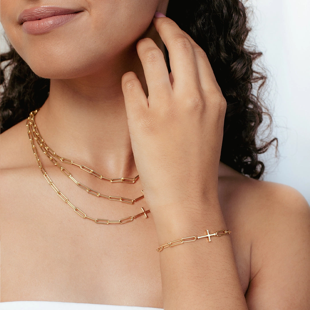close up of christian woman wearing the gold Chain Breaker Cross Bracelet from the Calvary Collection by Rizen Jewelry.