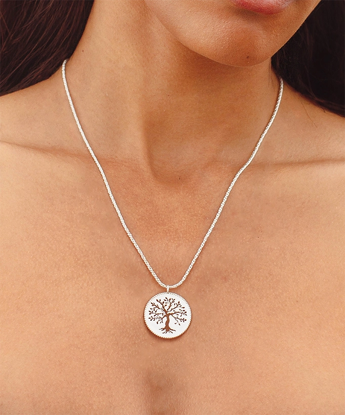 Close up of christian woman wearing silver Olive Tree Necklace from the Rooted Collection from Rizen Jewelry. 