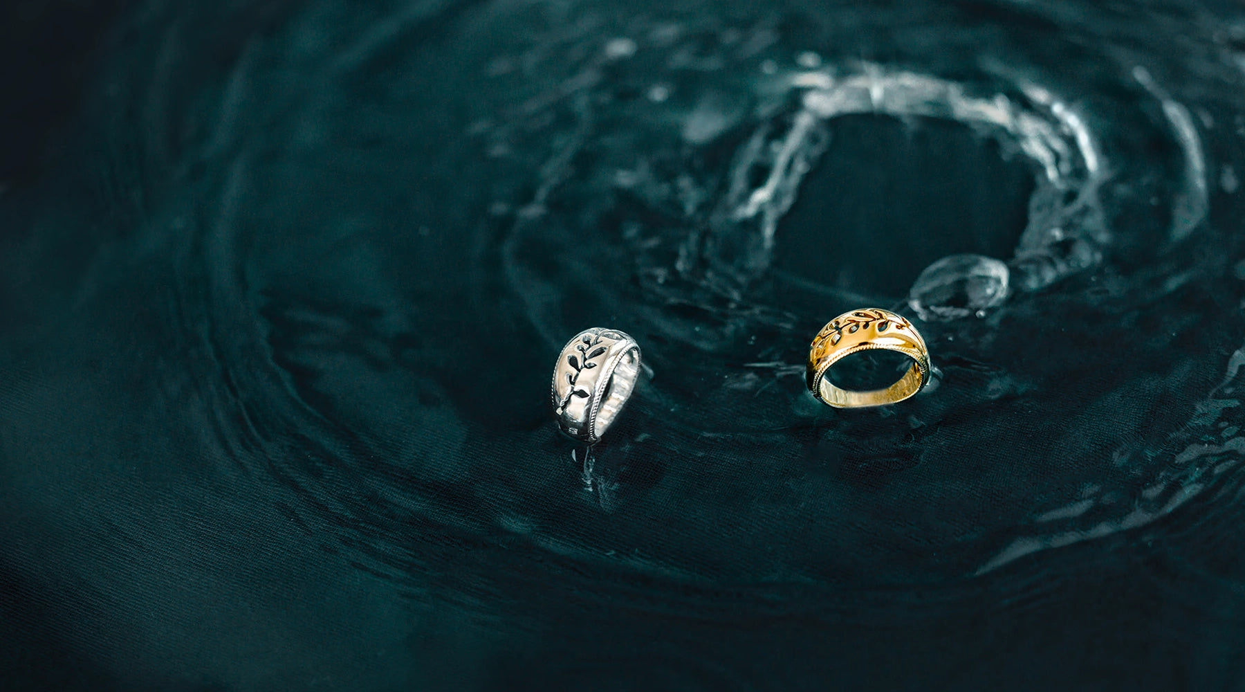 sterling silver and gold vermeil olive branch rings standing in water