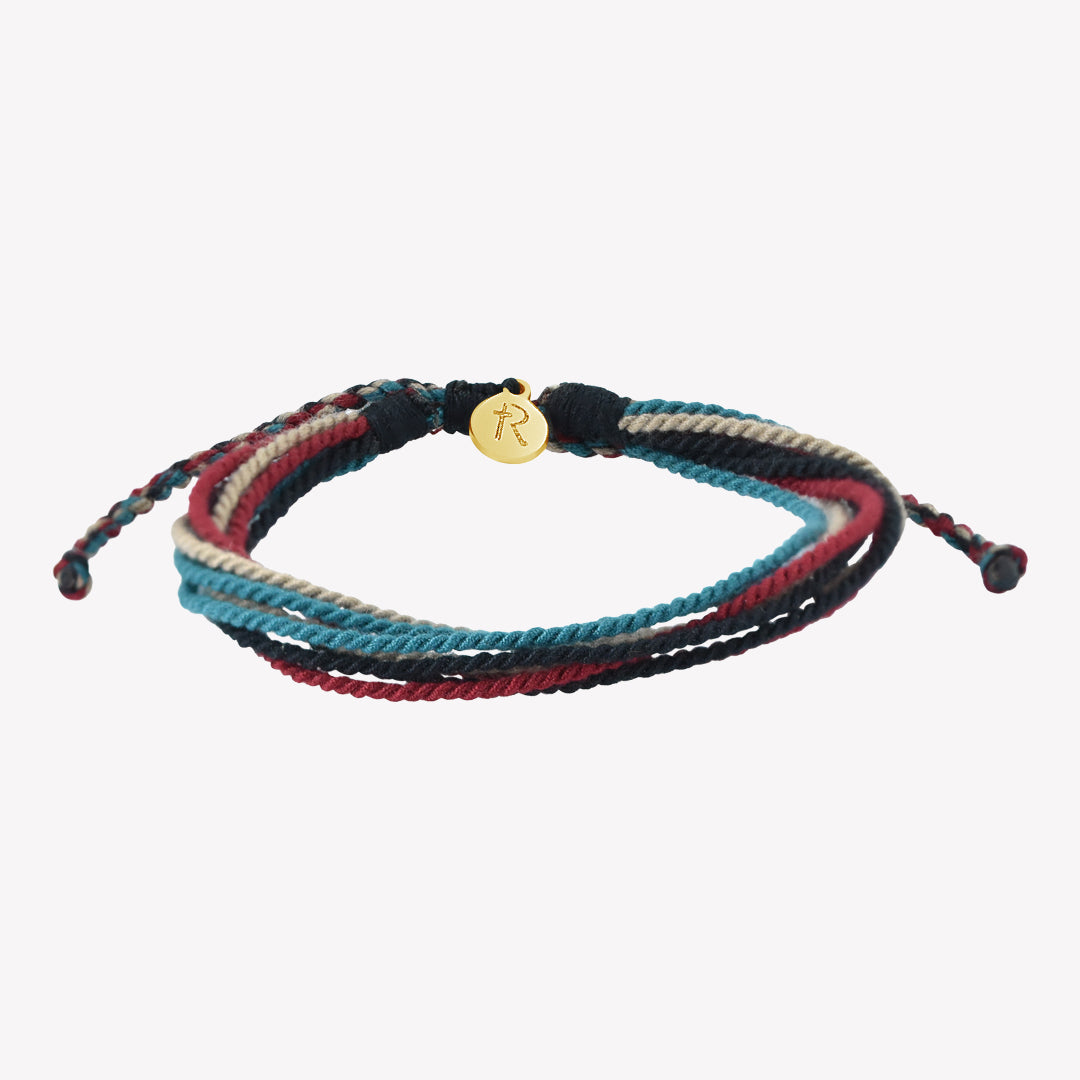 Rizen Jewelry Be Magnified Faithful multicord macrame bracelet. Cotton cords in black, garnet red, azure blue, and khaki with gold tag. Made 4 Ministries Collection. 