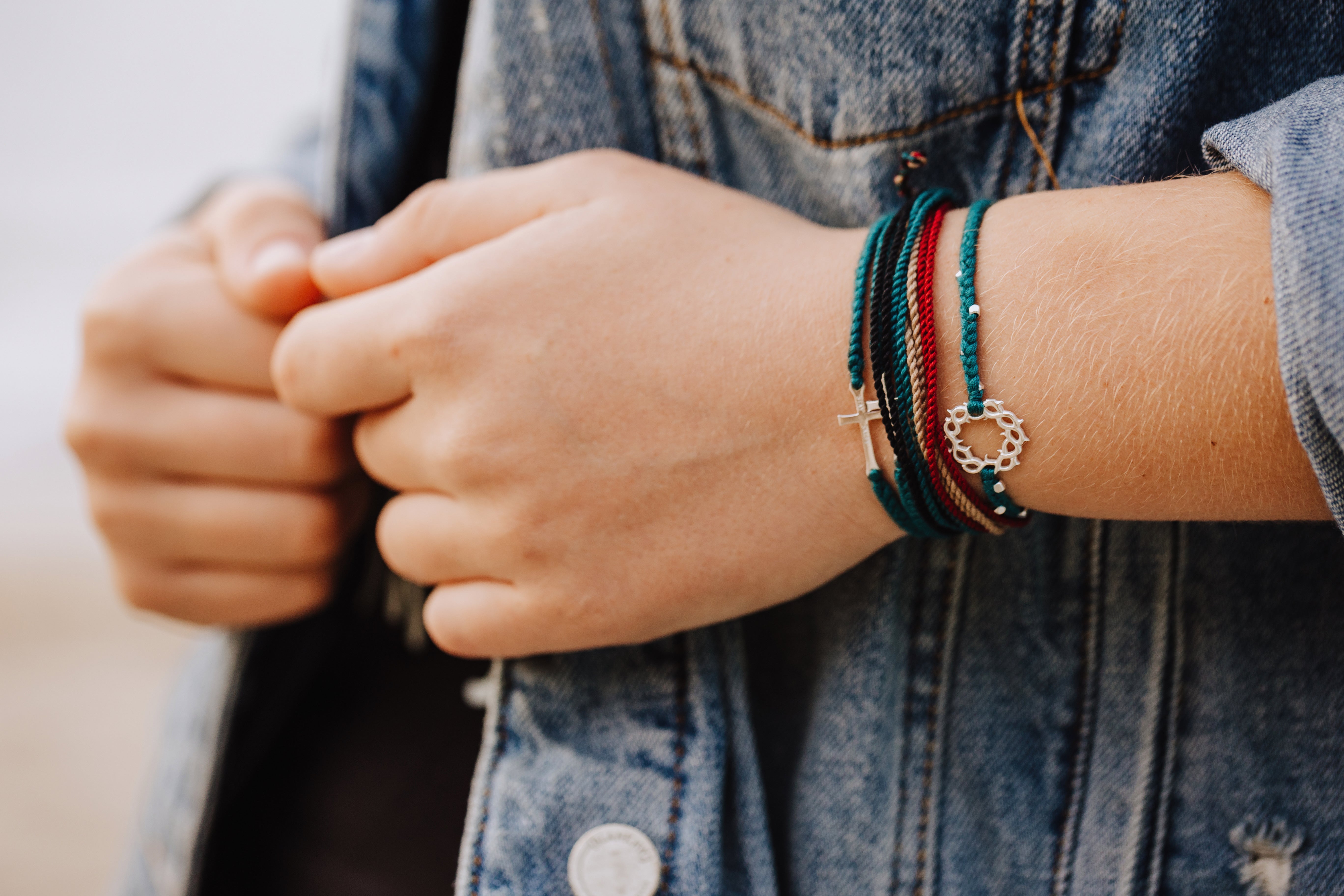 Azure blue braided friendship bracelet with silver crown of thorns pendant and 8 dainty beads layered with fatihful Be Magnified multi cord bracelets by Rizen Jewelry Made 4 Ministries round tag